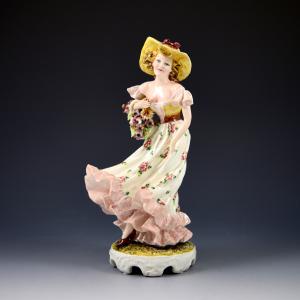 Ragazza con vestito al vento, cappello e canestro di fiori